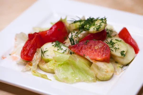 Färska grönsaker sallad och bröd på ett bord — Stockfoto