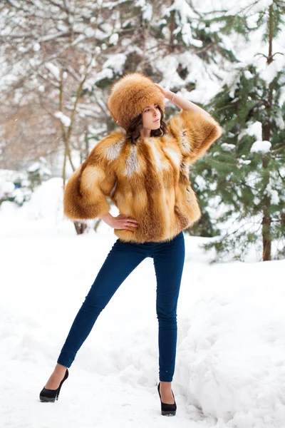 Menina bonita nova em um chapéu de pele e um casaco de pele de raposa vermelha — Fotografia de Stock