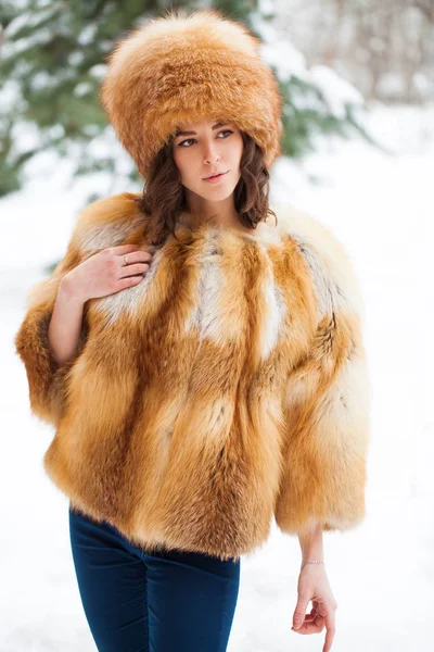 Молодая красивая девушка в меховой шапке и красной лисице — стоковое фото