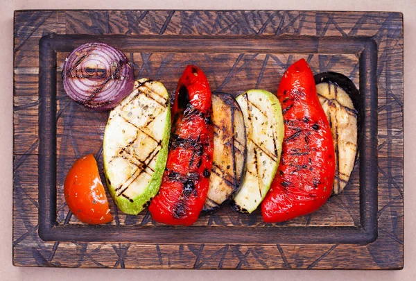 Grilled vegetables of different colors on wooden dish — Stock Photo, Image