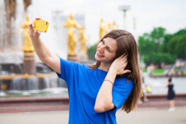 Gülümseyen kadın almak bir fotoğrafını bir akıllı telefon ile. Selfi