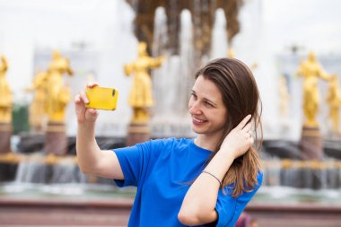 Gülümseyen kadın almak bir fotoğrafını bir akıllı telefon ile. Selfi