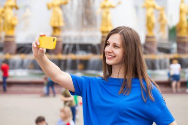 Gülümseyen kadın almak bir fotoğrafını bir akıllı telefon ile. Selfi