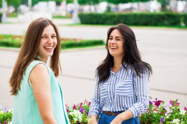 İki genç kadın birbiriyle konuşuyor.
