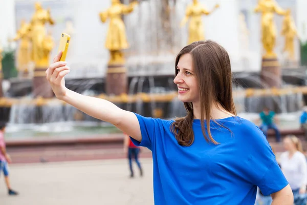 微笑的女人拍一张照自己的智能手机。光谱分析中的应用 — 图库照片