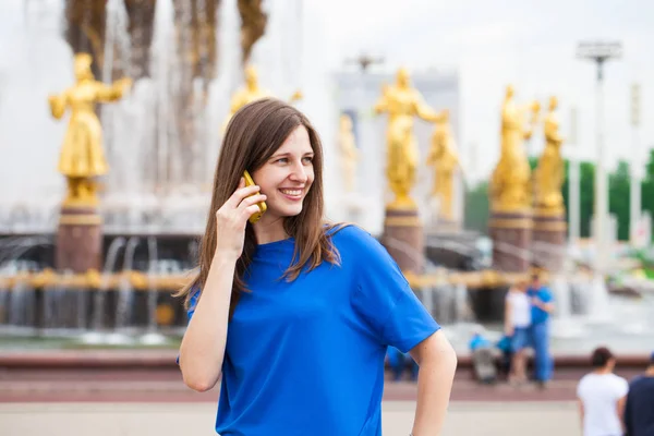 Mooie jonge brunette vrouw bellen via de telefoon — Stockfoto