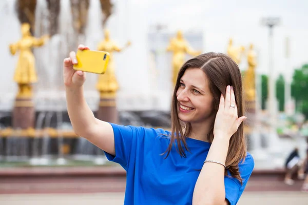 Mujer sonriente tomar una foto de sí misma con un teléfono inteligente. Selfi. —  Fotos de Stock