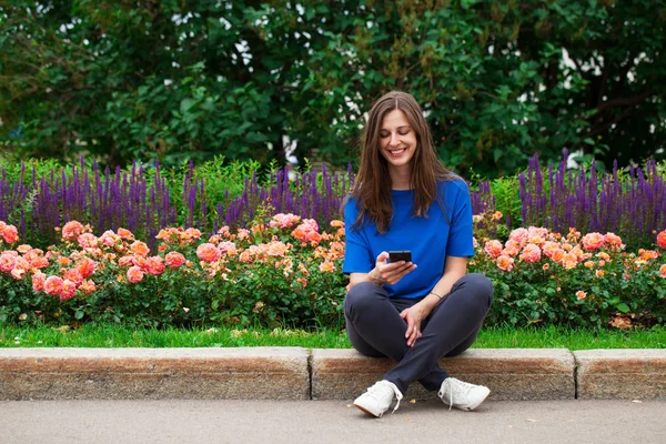 Jonge brunette vrouw lezen van een bericht op de telefoon — Stockfoto