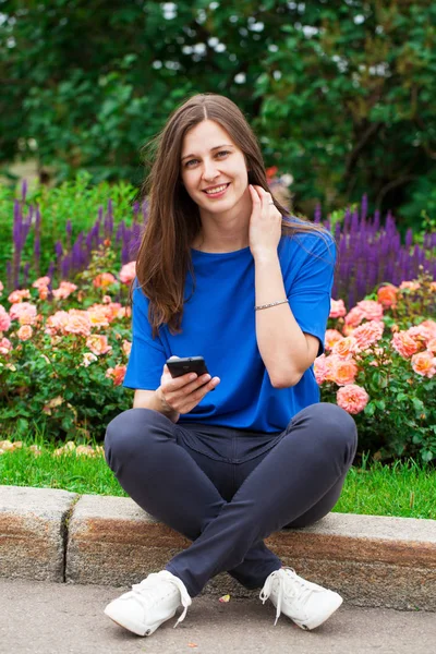 Mladá bruneta žena čtení zpráv na telefonu — Stock fotografie