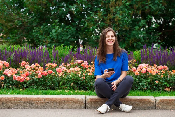 Giovane donna bruna che legge un messaggio al telefono — Foto Stock