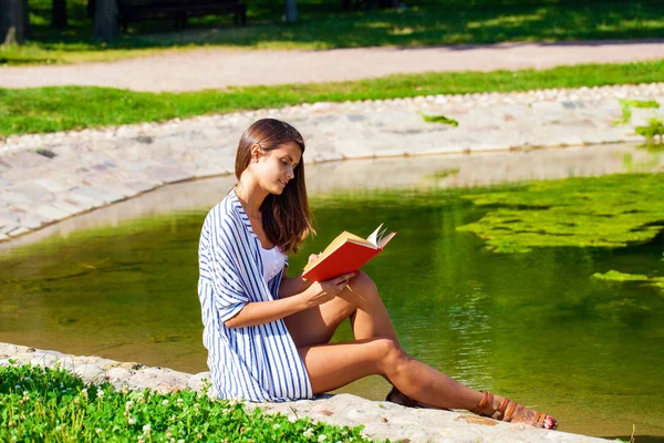 Porträt einer hinreißenden jungen Brünetten beim Lesen eines Buches — Stockfoto