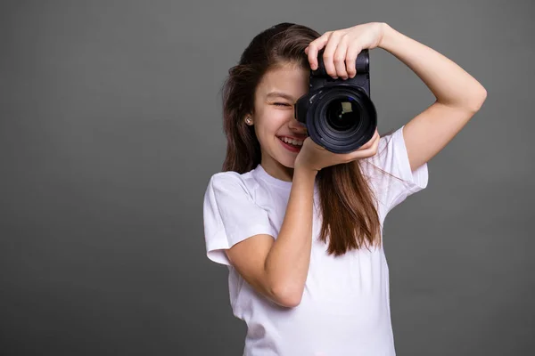 Linda morena niña sosteniendo una cámara de fotos — Foto de Stock