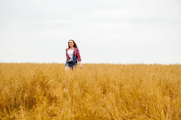 Mladá krásná žena chůze v pole, léto venku — Stock fotografie