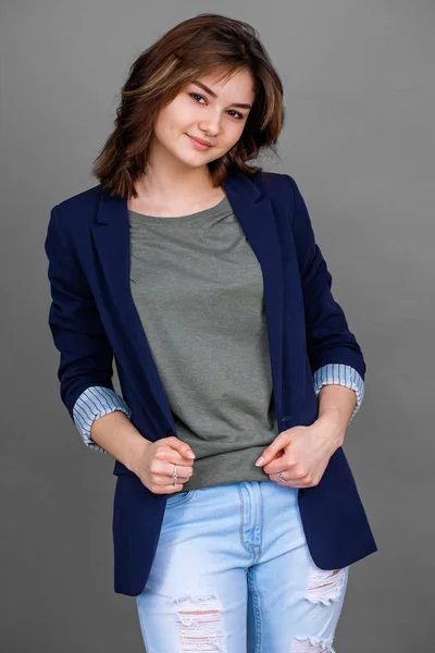 Portret van jonge brunette in zakelijke stijl op grijze achtergrond — Stockfoto