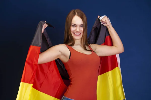 Молодий красива жінка тримає великий прапор Німеччини — стокове фото