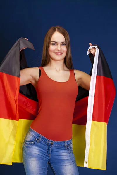 Jovem mulher bonita segurando uma grande bandeira da Alemanha — Fotografia de Stock
