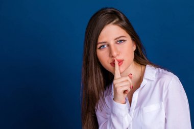 Güzel esmer kadın işaret parmağı s işareti olarak dudaklarını koydu