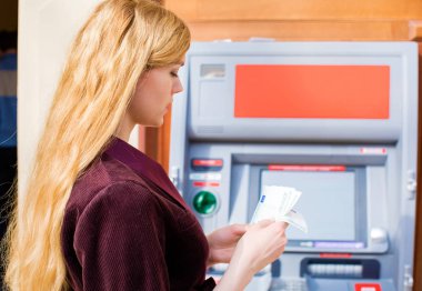 Genç sarışın kadın bir nakit dolar tutuyor