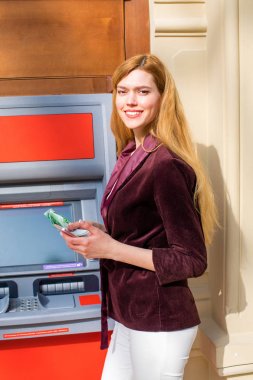 Arka planda alışveriş merkezi Atm üzerinde sarışın kadın