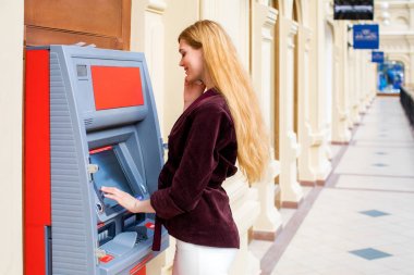 Arka planda alışveriş merkezi Atm üzerinde sarışın kadın
