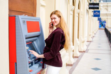 Arka planda alışveriş merkezi Atm üzerinde sarışın kadın
