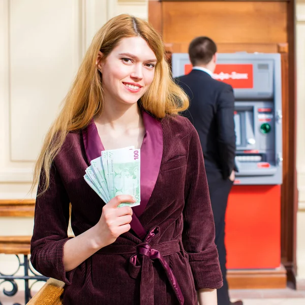 Νεαρή ξανθιά γυναίκα κρατά μια μετρητά δολάρια — Φωτογραφία Αρχείου