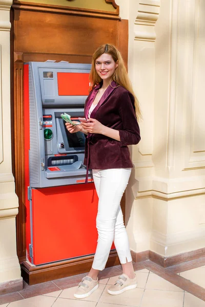 Блондинка на заднем плане в торговом центре банкомат — стоковое фото