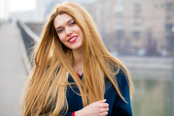 Portrait of a young beautiful woman in blue coat — Stock Photo, Image