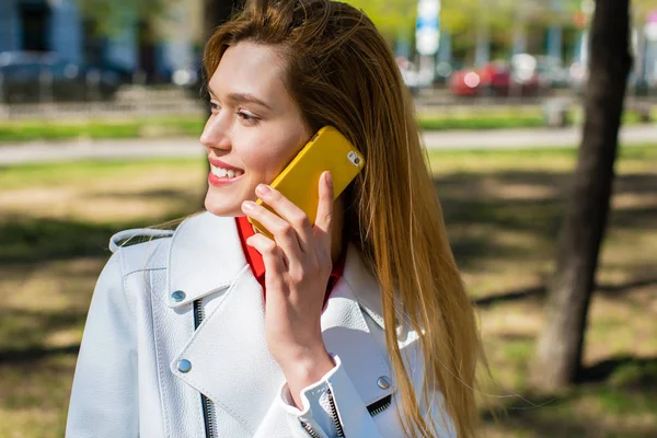 Vackra unga blonda kvinnan ringer via telefon — Stockfoto