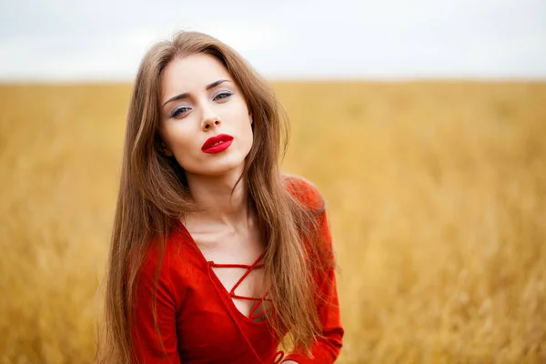 Portrét mladé ženy bruneta v červených šatech — Stock fotografie