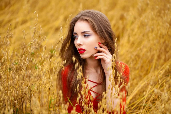 Portret van een jonge brunette vrouw in rode jurk — Stockfoto
