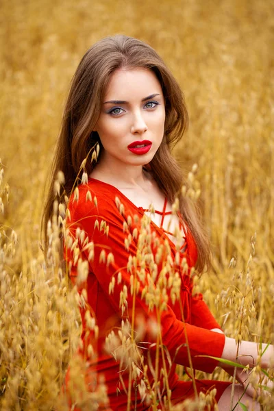 Porträtt av en ung brunett kvinna i röd klänning — Stockfoto
