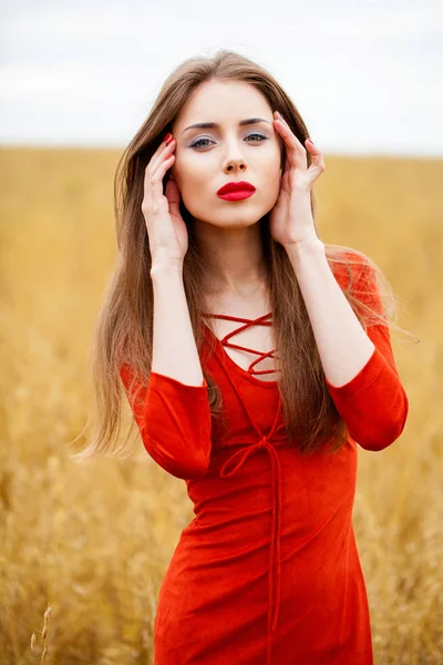 Portrait of a young brunette woman in red dress — Stock Photo, Image