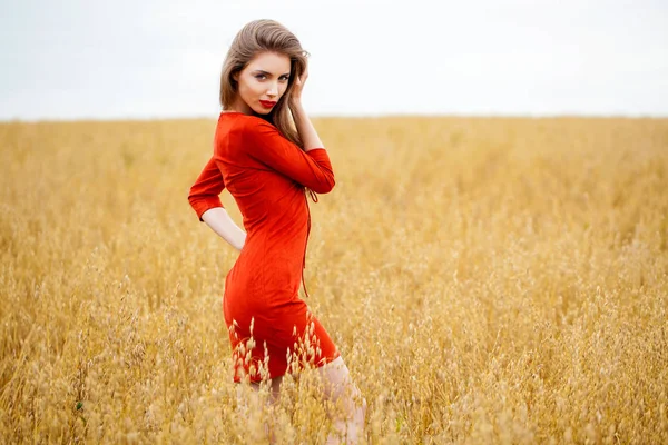 Portret van een jonge brunette vrouw in rode jurk — Stockfoto