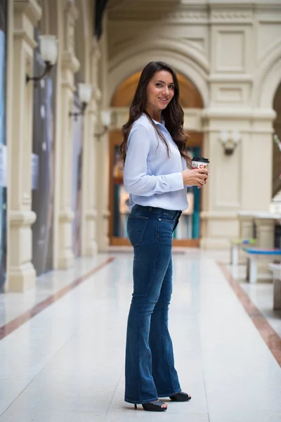 Mladá krásná brunetka žena v modré džíny a halenku, pěší — Stock fotografie