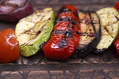 Ahşap tabak üzerinde farklı renkteki ızgara sebze 