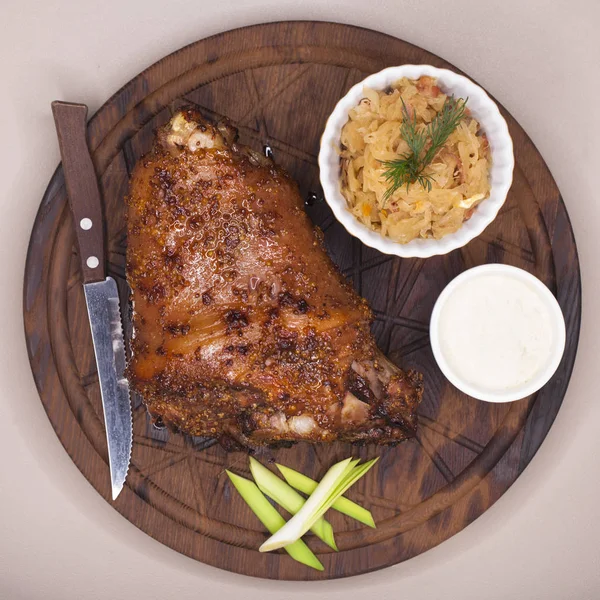 Piatto di ristorante - grande nocca di maiale al forno su un vassoio di legno — Foto Stock