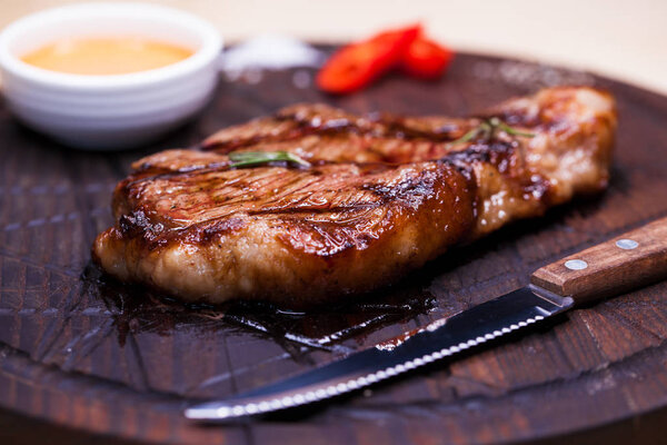 Restaurant dish - beef steak on a wooden plate