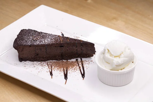 Stuk chocolade amandel maïsmeel taart en ijs Stockfoto
