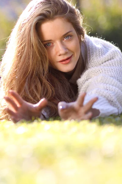 Portrait of a young beautiful girl lying on the lawn in autumn p — Stock Photo, Image