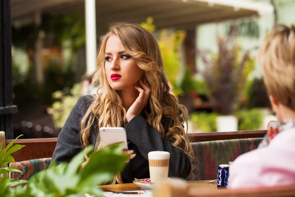 Молодая женщина пьет коктейль в кафе — стоковое фото