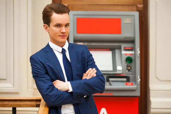 Businessman in a blue suit stands against the background of an A — Stock Photo, Image