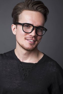 Büyük gözlüklü genç bir adam portresi stüdyo