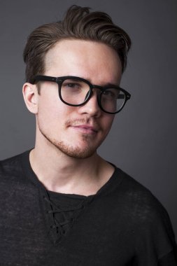 Büyük gözlüklü genç bir adam portresi stüdyo