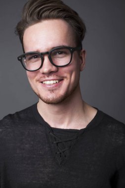 Büyük gözlüklü genç bir adam portresi stüdyo