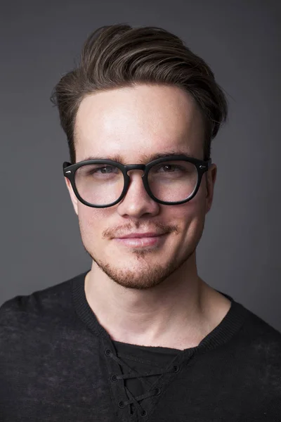 一个戴着大眼镜的年轻人的画室肖像 — 图库照片