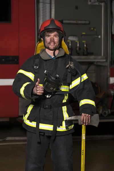 Portrait d'un jeune pompier sur le fond d'un camion de pompiers — Photo