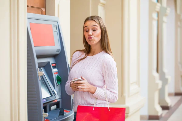 Wanita pirang di latar belakang ATM pusat perbelanjaan — Stok Foto