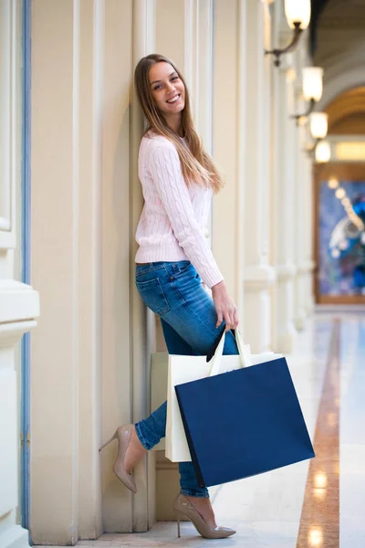 Mladá šťastná žena s nějakou nákupní tašky v obchoďáku — Stock fotografie