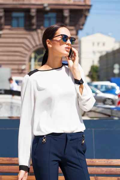 Joven mujer de negocios con gafas de sol de espejo azul llamando por ph — Foto de Stock